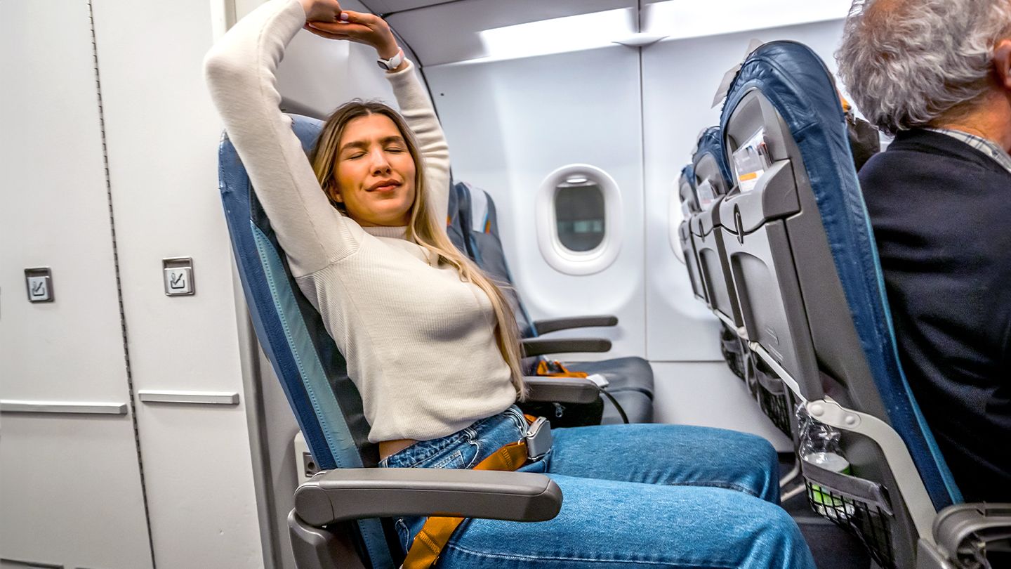 woman stretching on airplane